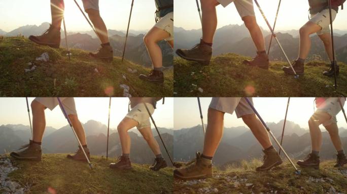 镜头耀斑: 穿着远足靴的游客夫妇在阿尔卑斯山的草木上行走。
