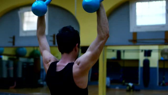 健身房里的健美运动员，用杠铃，卧推，改善三头肌，大胸肌，前三角肌。