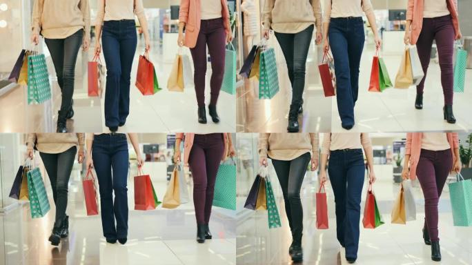 女士的腿在购物中心走路时，带着纸袋享受着购买衣服和礼物的乐趣。青年生活方式、友谊和消费主义观念。