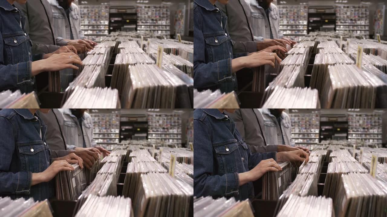 无法识别的多样化客户在唱片商店中寻找黑胶唱片