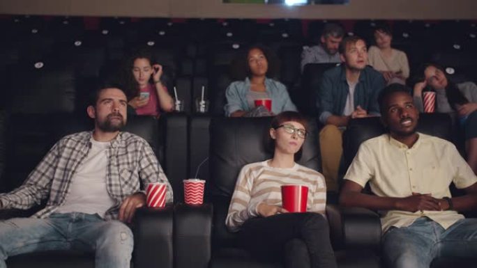 年轻人在电影院打哈欠看无聊电影的慢动作