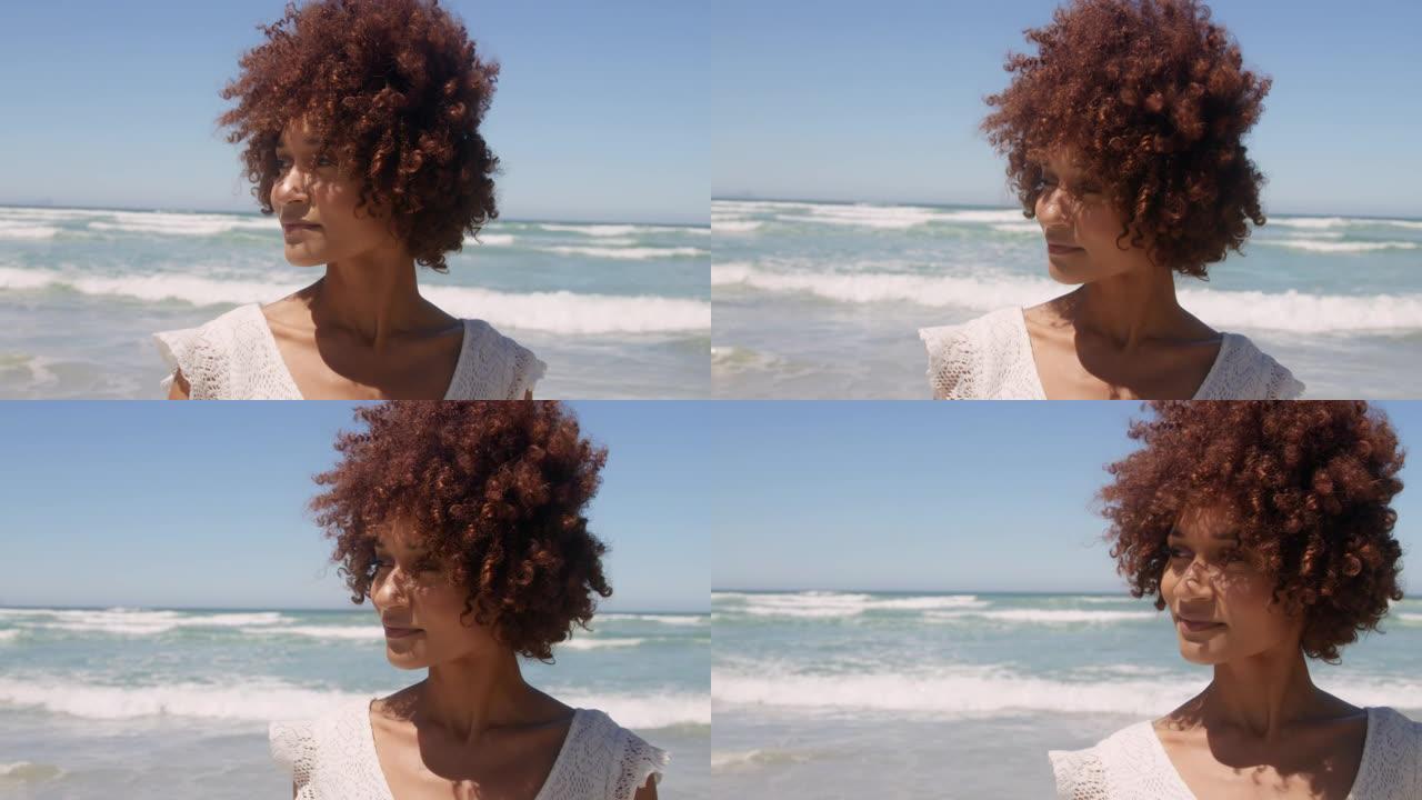 年轻的非洲裔美国妇女在阳光下在海滩上行走的前视图4k