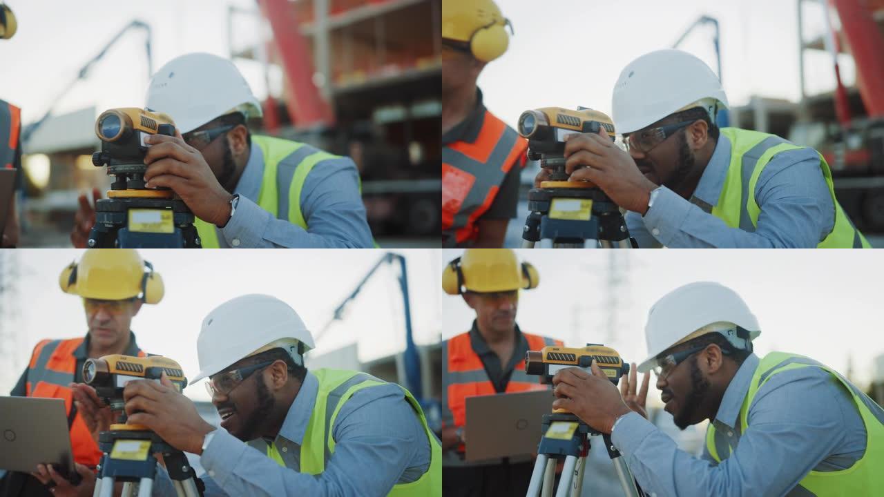 在商业/工业建筑施工现场: 专业工程师测量师用经纬仪采取措施，工人使用笔记本电脑。背景摩天大楼模板框