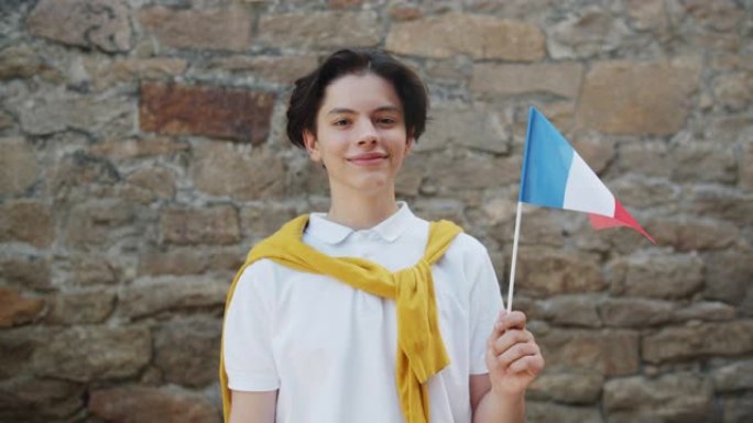 法国少年在户外举着法国国旗微笑的肖像