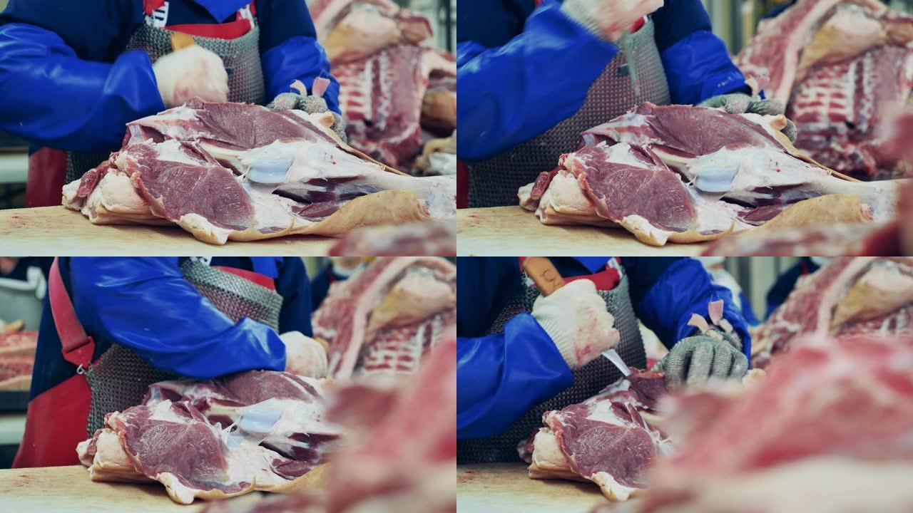 肉厂员工正在切大块猪肉