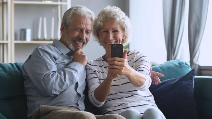 快乐的中年家庭玩得开心，在智能手机上自拍。