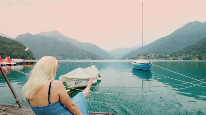 女士无忧无虑的年轻女性游客在意大利加尔达湖的湖中泼水