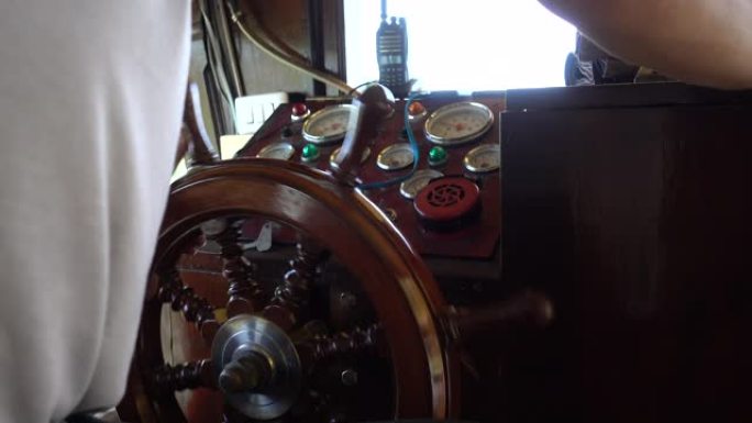船长在仪表控制面板上转动船方向盘