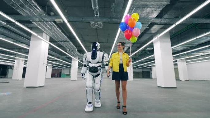 一个女人在一个有半机械人的房间里散步时手里拿着气球。