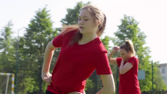 女子足球运动员在室外体育场进行髋关节旋转