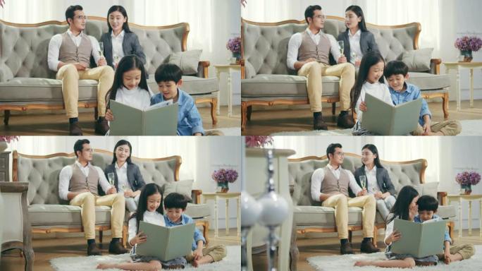 两个亚洲孩子在家读书，父母在背景下