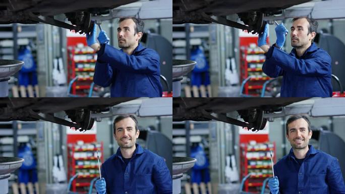 在车库里，使用平板电脑的机械师使机油和发动机检查对汽车微笑。