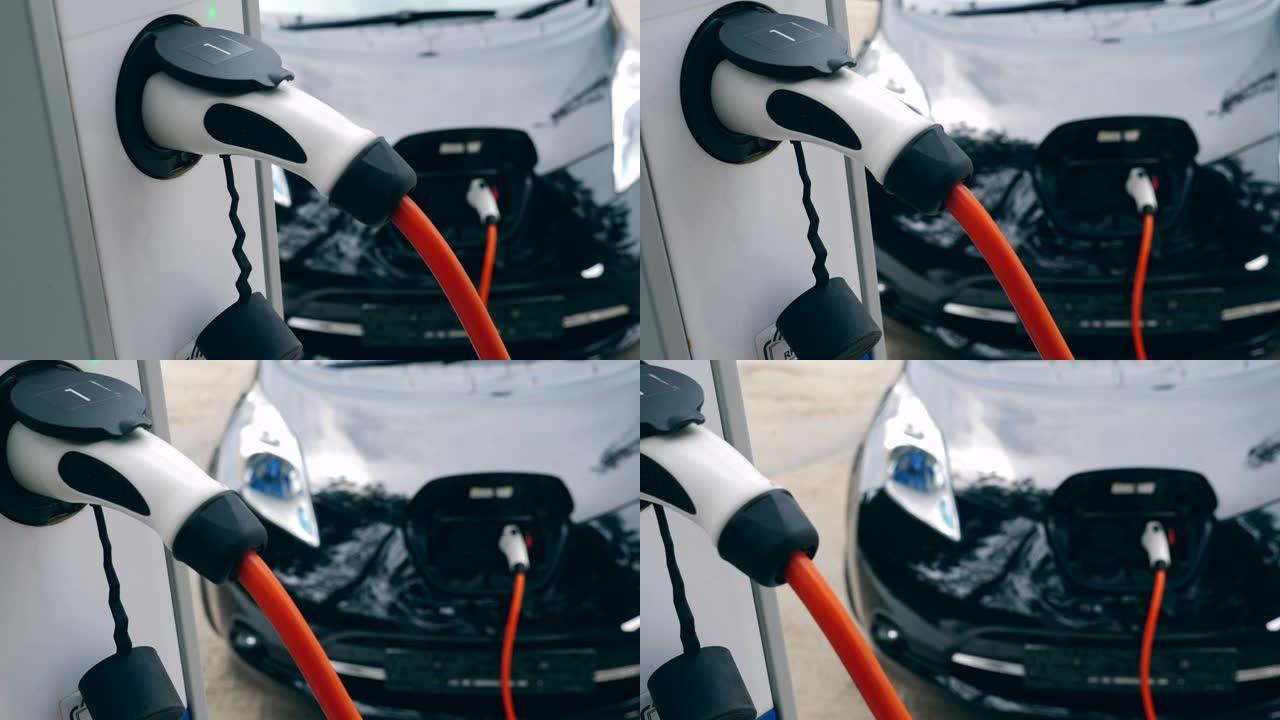 白色充电器与电动手机配合使用，给它充电。创新的电动混合动力汽车充电。