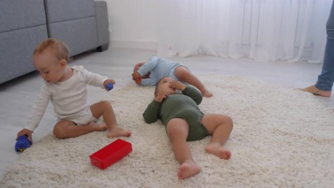 婴儿三胞胎在家里蓬松的地毯上放松