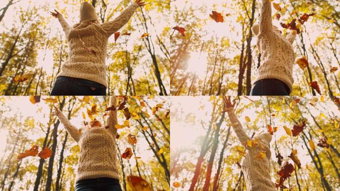 MS超级慢动作无忧无虑的年轻女子在森林中扔金色的秋叶