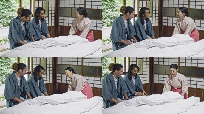 房东在一家日本酒店向年轻夫妇解释蒲团