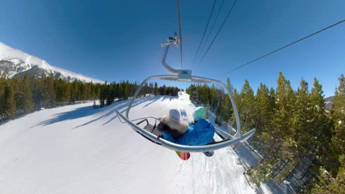 年轻的滑雪者在晴天乘坐升降椅并观察风景秀丽的大自然