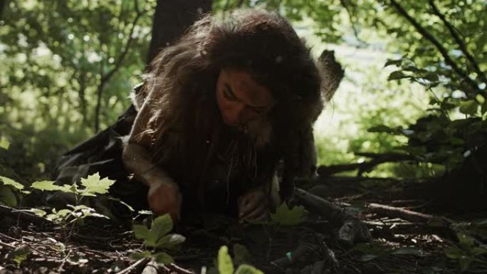 史前洞穴妇女狩猎采集者在森林中寻找坚果和浆果。原始尼安德特人妇女在阳光明媚的森林中寻找食物