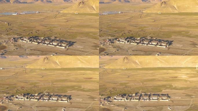 无人机: 在西藏崎岖的荒野中绕着一个乡村小镇飞行。