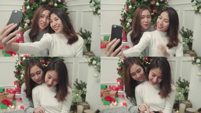 一群快乐快乐的年轻亚洲女性使用带有圣诞树的智能手机自拍在圣诞节期间在家装饰她的客厅。生活方式女性庆祝