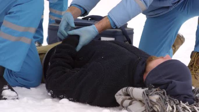 医护人员检查躺在雪地上的人