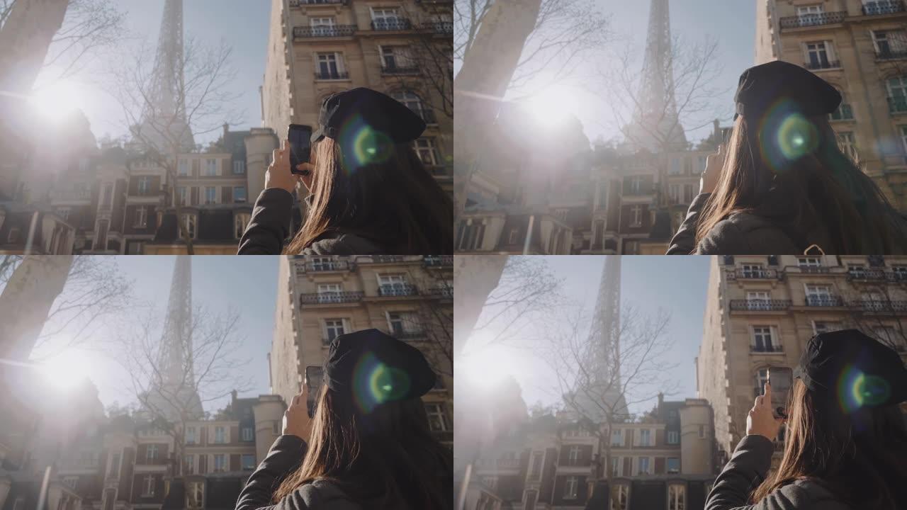 快乐美丽的旅游女人在巴黎度假时拍摄艾菲尔铁塔的智能手机照片，惊人的镜头闪光慢动作。