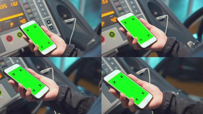 女性在健身房使用智能手机，绿屏