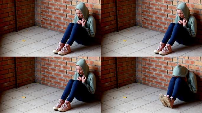 悲伤的女学生独自坐在地板上