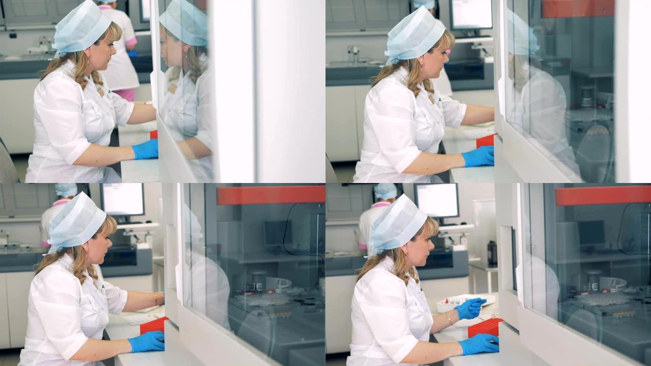 实验室里的人用设备工作。女工坐在桌旁，医用离心机旋转。