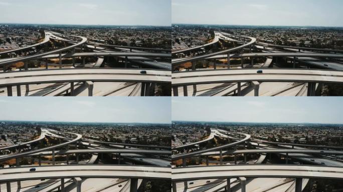 无人驾驶飞机在洛杉矶史诗般的高速公路交叉口的多层交叉路口上空飞行，有复杂的立交桥。