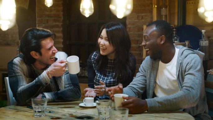 微笑的朋友在咖啡馆喝咖啡和玩手机的慢动作