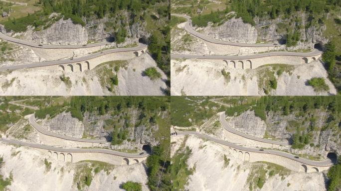 空中: 在意大利阿尔卑斯山的空高架桥上行驶的跑车和摩托车。