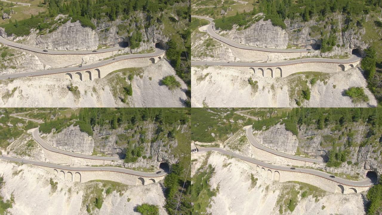 空中: 在意大利阿尔卑斯山的空高架桥上行驶的跑车和摩托车。