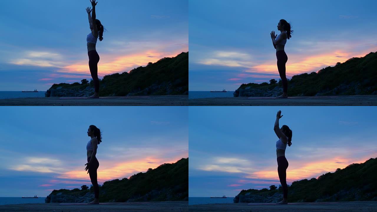 剪影年轻女子正在山海练习瑜伽。