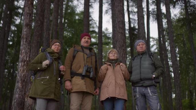 一群高级徒步旅行者在森林里为相机摆姿势