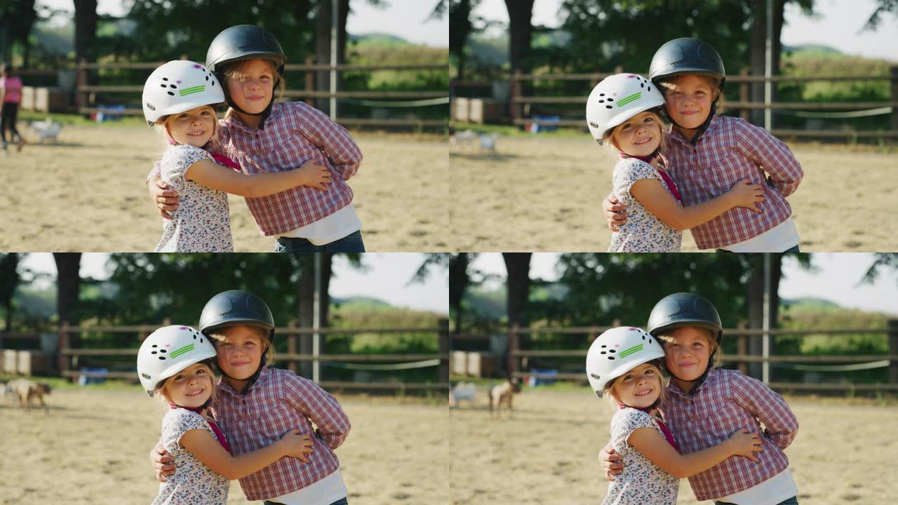 在一个阳光明媚的日子里，两个戴着骑师头盔的小女孩在镜头前微笑着骑着马