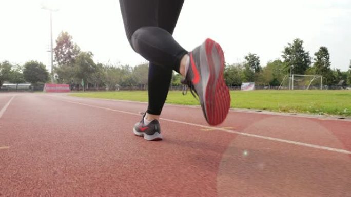 慢动作: 女跑步者在跑道上跑步，腿部特写