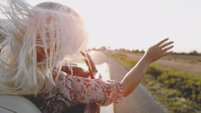 SLO MO女士无忧无虑的年轻女子骑着敞篷车沿着阳光明媚的乡村田野骑行