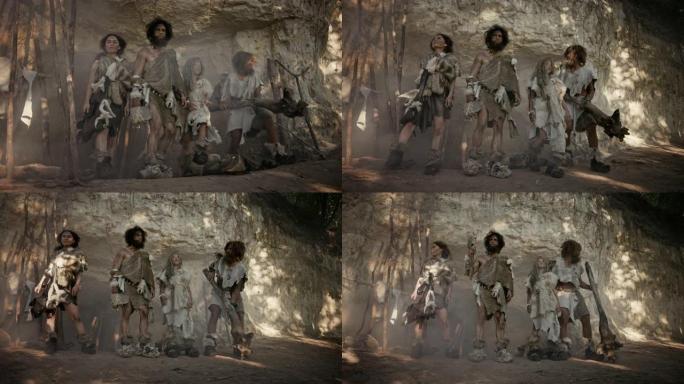 由四个狩猎采集者组成的部落，他们戴着动物皮，拿着石尖工具，在他们的洞穴入口处摆姿势。两个成年男性和两