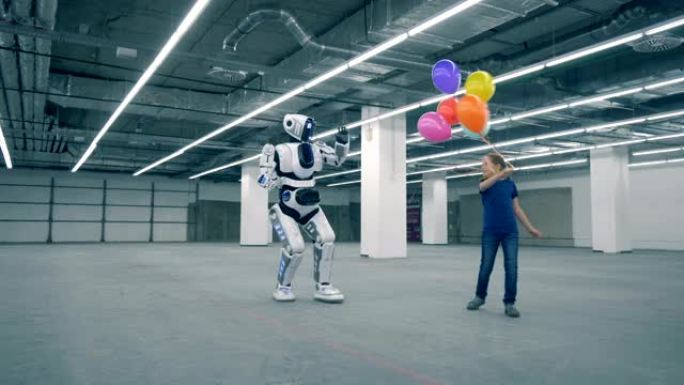 十几岁的女孩正在与气球跳舞，并与类似人类的机器人同行