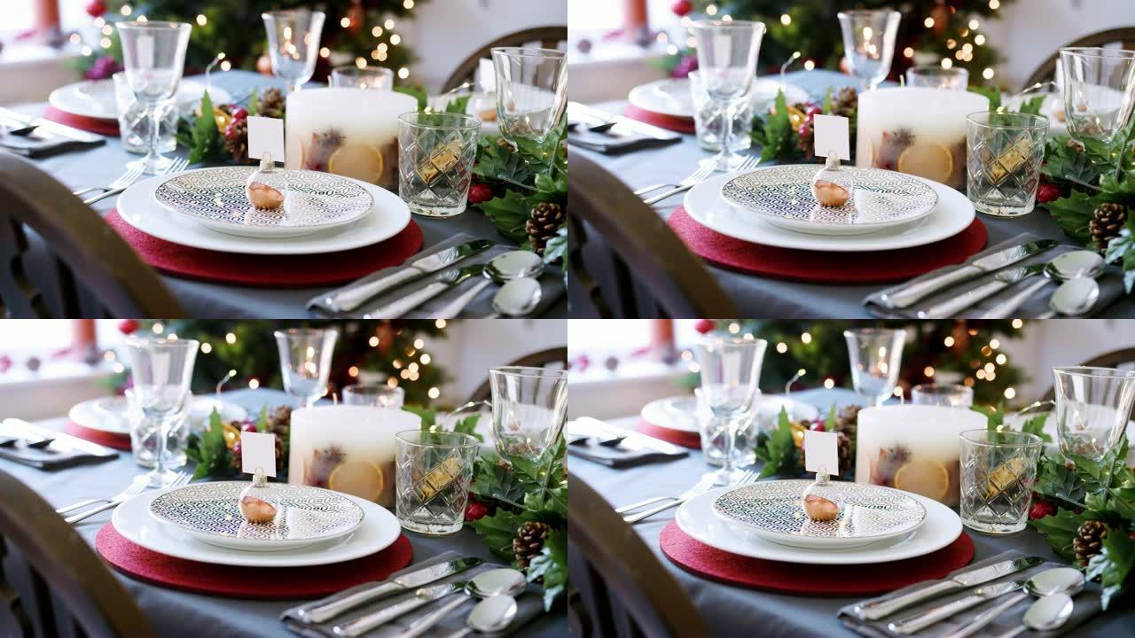 一个节日圣诞餐桌，盘子上摆着摆设的名片夹，绿色和红色季节性装饰，细节
