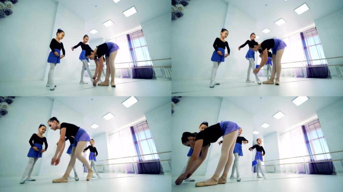 芭蕾舞教练将女孩的脚放在正确的位置