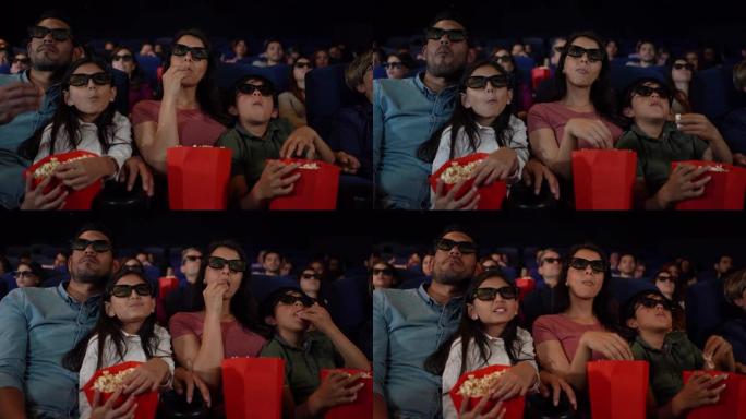 拉丁美洲家庭一边享受3D电影，一边吃零食，看起来很投入