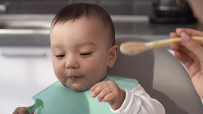 草率的1岁亚洲婴儿被喂食果泥