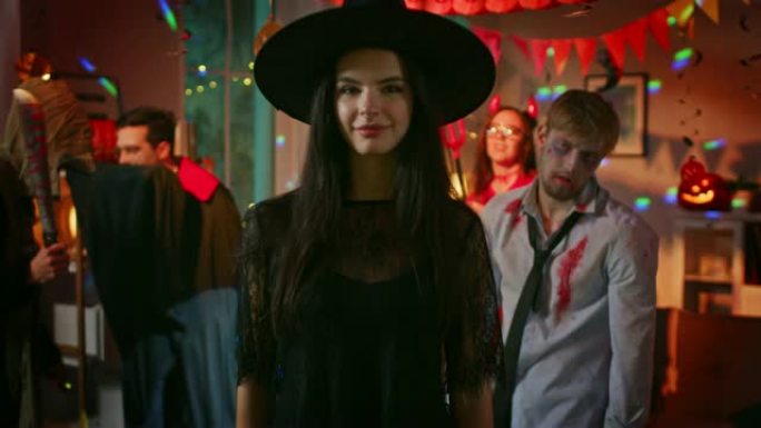 万圣节服装派对: 华丽的年轻女巫穿着礼服和帽子诱人的姿势。背景: 美丽的她魔鬼，可怕的死亡，德古拉伯