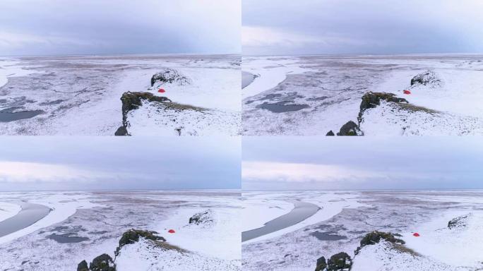 冰岛悬崖上俯瞰偏远冰雪覆盖景观的WS风景鸟景露营帐篷