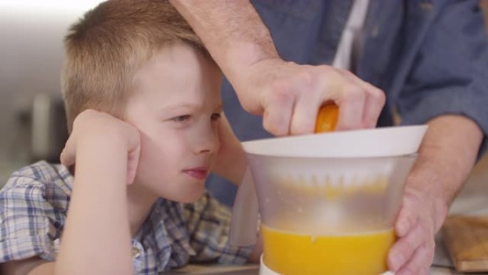 儿子看面目全非父亲挤橙汁