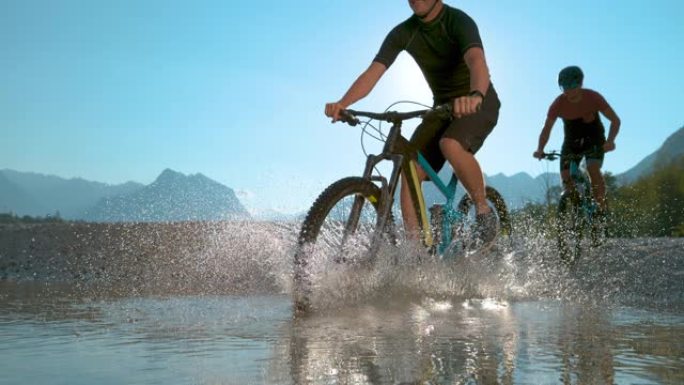 剪影: 朋友在索卡河骑自行车时向相机喷水