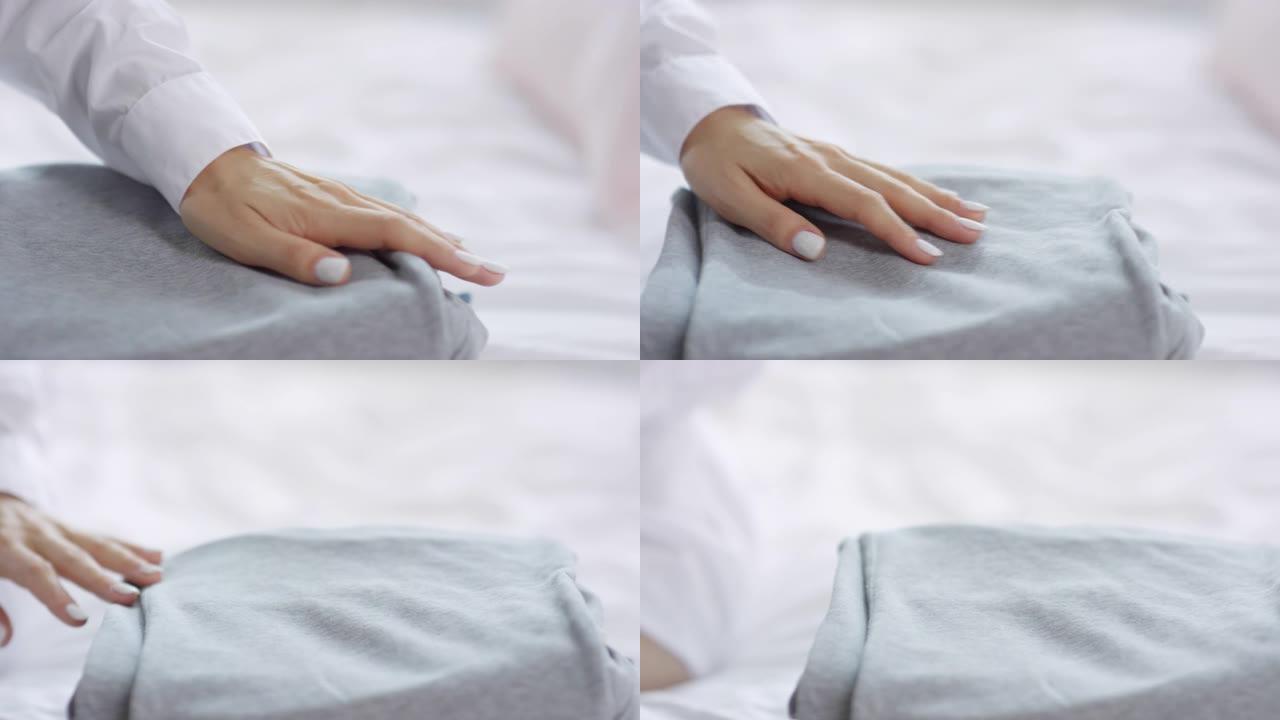 穿着白衬衫的女人的手在床上抚摸便服
