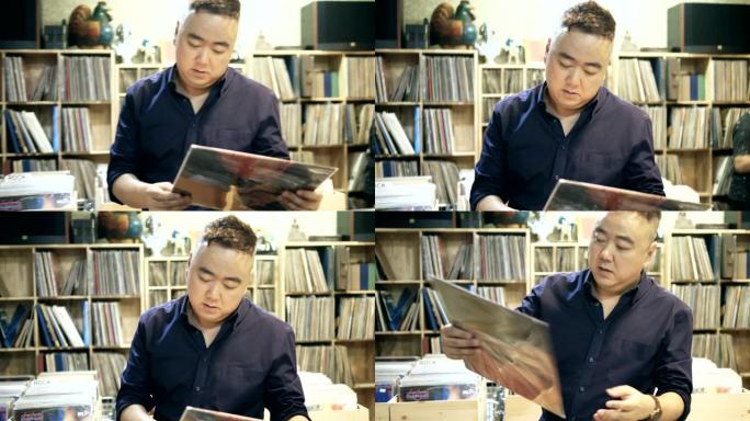 唱片店的亚洲男子男人看书读书